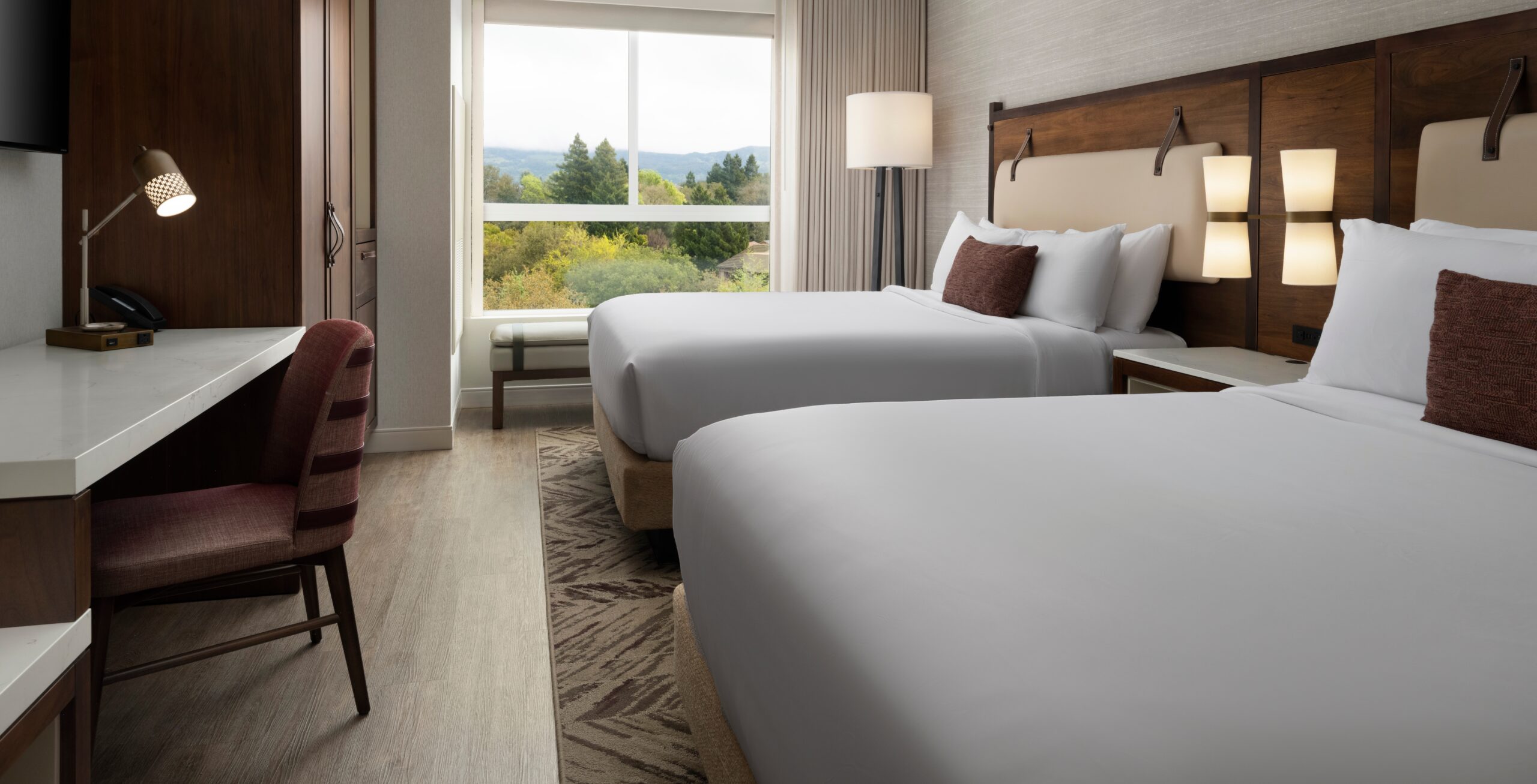 Double queen beds and view of outside through The Knoll Hotel window.